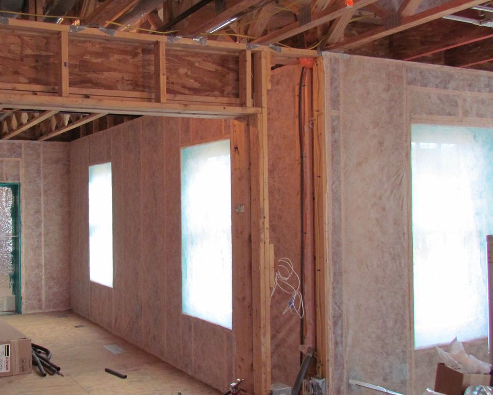 Netting stapled across wood-framed walls ready to hold blown-in cellulose insulation